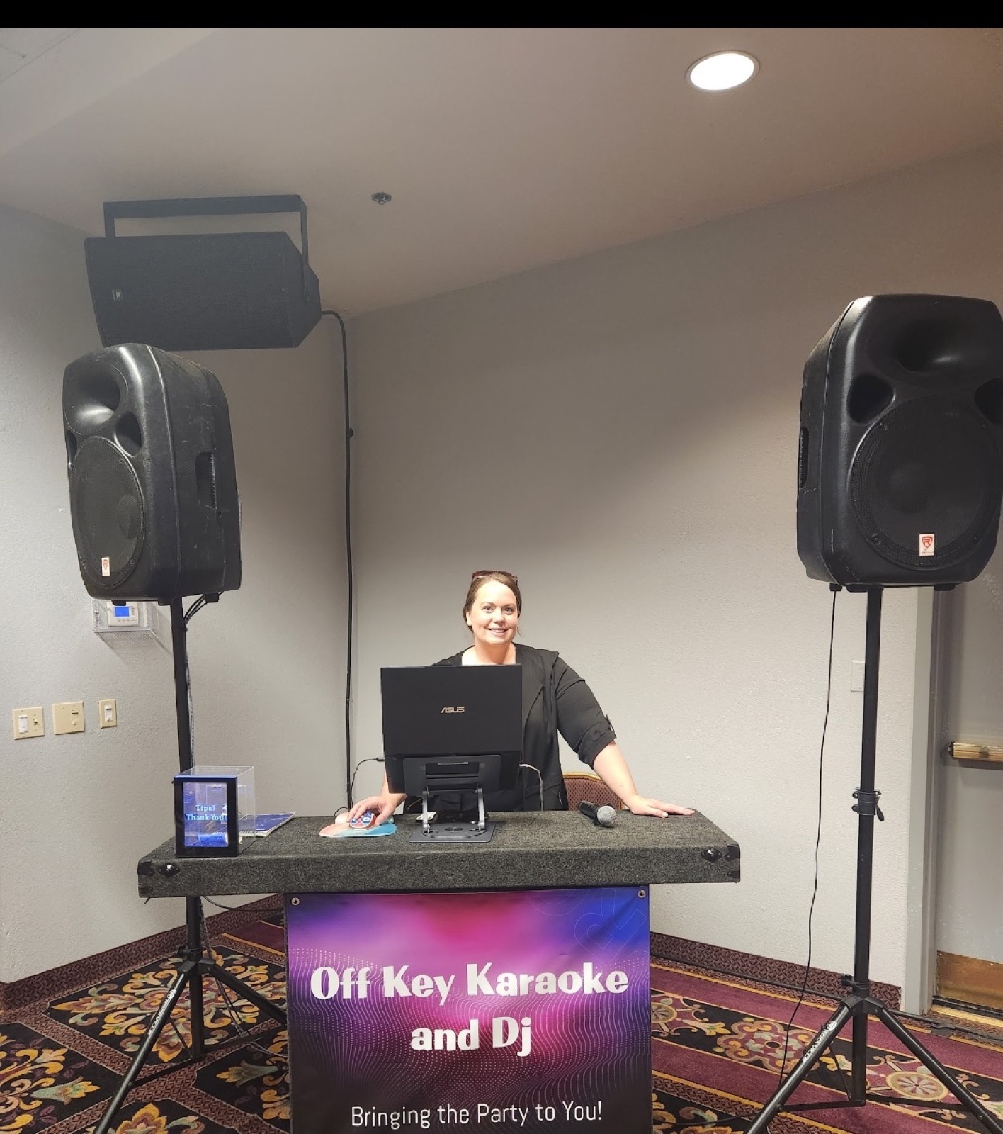 Off Key DJ at a complete sound setup for an indoor event