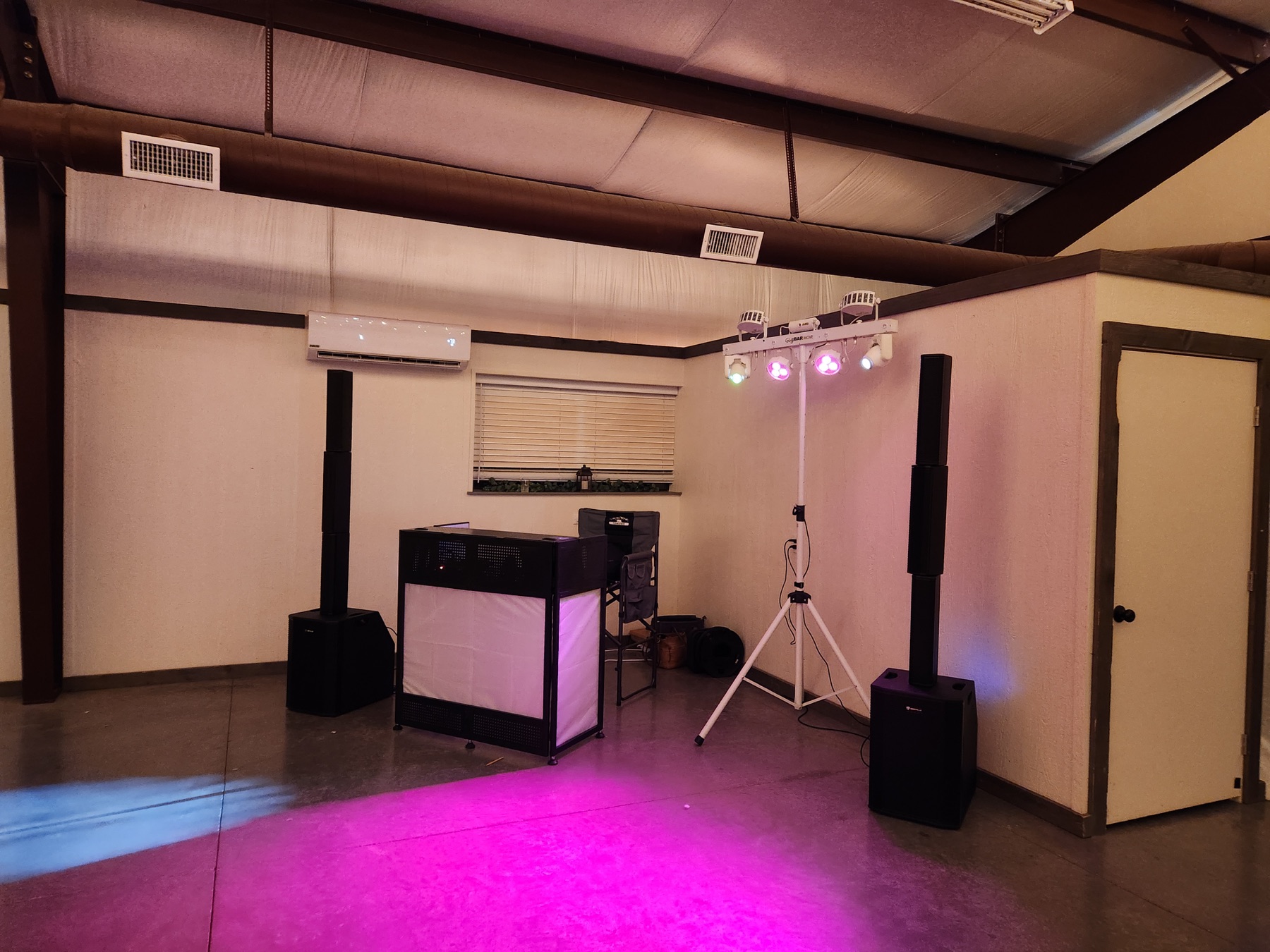 Wide view of an Off Key DJ booth, sound system, and dance-floor lighting